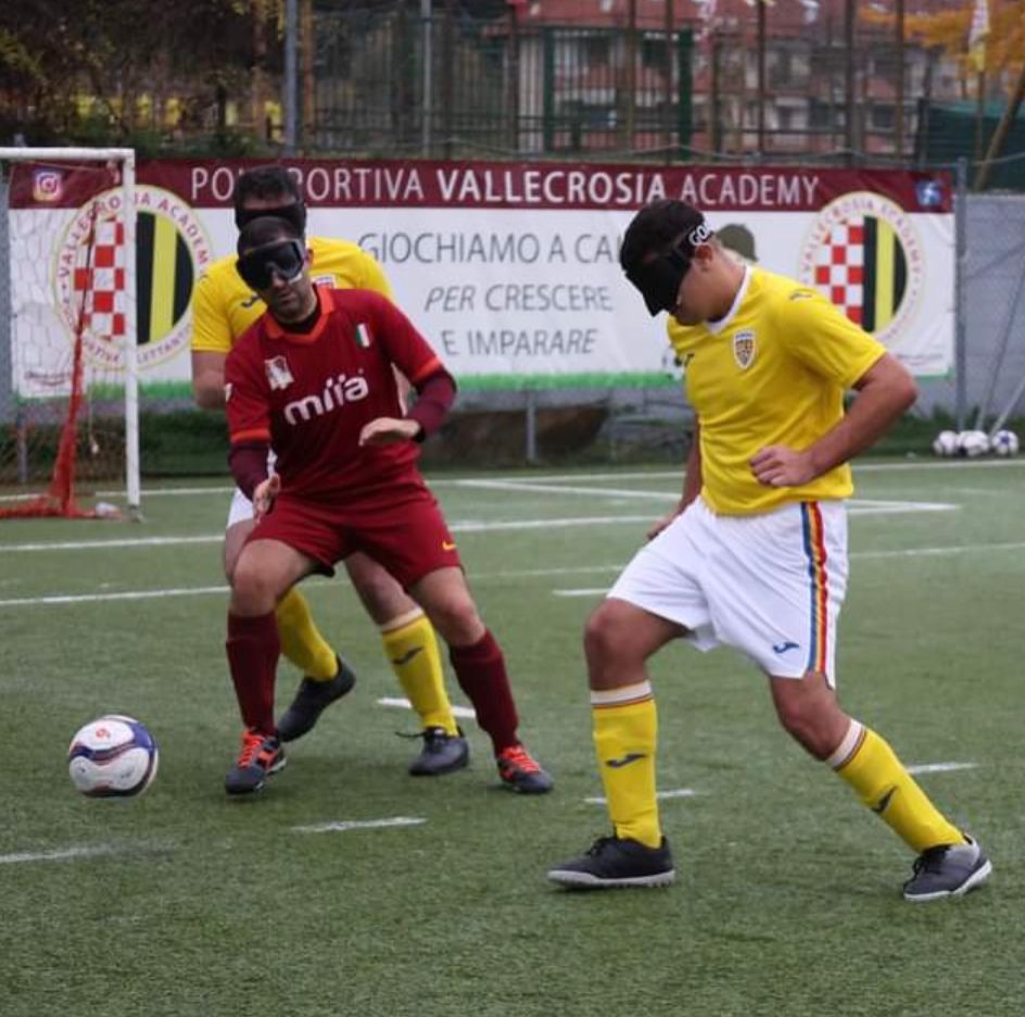 Campionato Europeo 2023. Trasferta a Sanremo. In foto il giocatore della Roma Blind Football cerca di allontanare il pallone dei giocatori della squadra avversaria che indossano un completo in pantaloncini color bianco e maglietta color giallo.